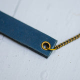 navy blue minimalist rectangular leather neck piece with antique details